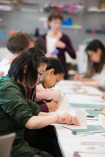 A participant uses technique to bind her writing journal, photographed by Noel Photos, © IU Libraries. 
